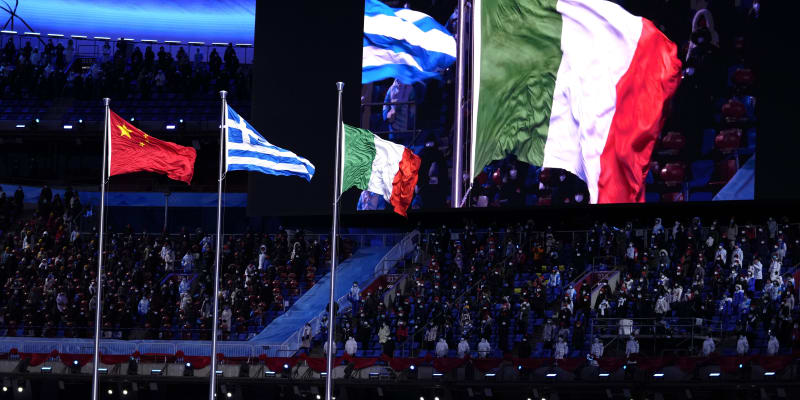 Slavnostní ceremoniál k ukončení ZOH 2022. Čínská vlajka pro pořadatele končících her, řecká coby kolébka olympijských her a italská pro budoucí pořadatele. Další turnaj pod pěti kruhy se zimními sporty se totiž v roce 2026 koná v italském Miláně a Cortině d'Ampezzo.