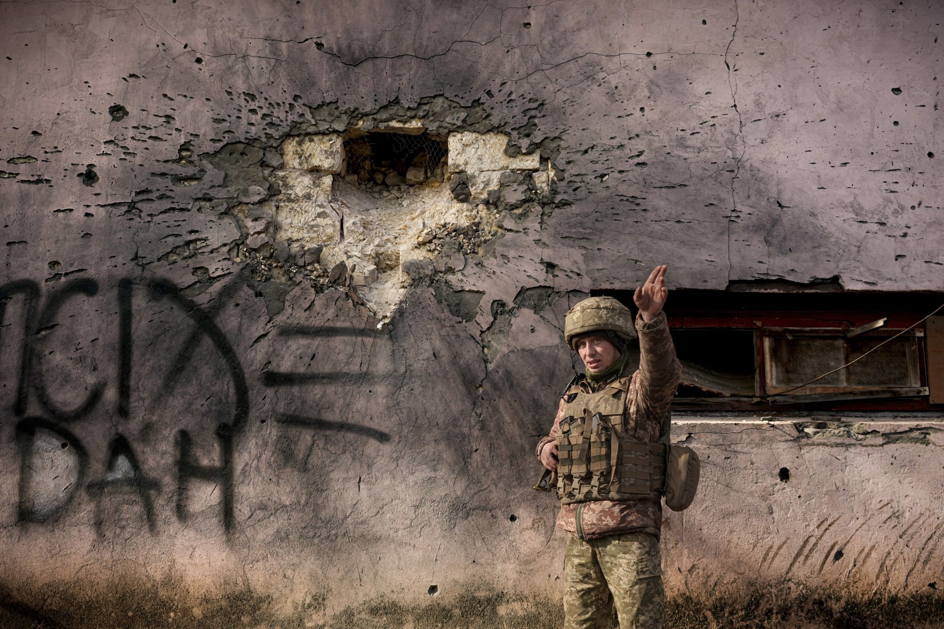 Ukrajinský voják před zdí, kterou zasáhl minomet