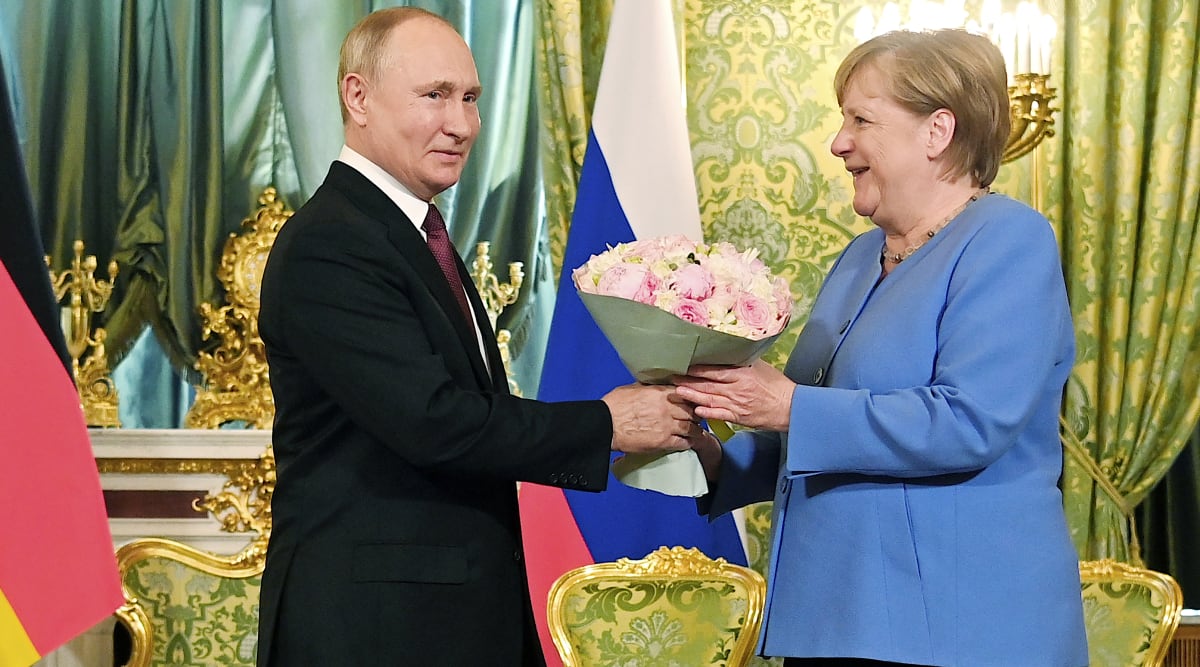 Německá kancléřka Angela Merkelová přijímá květiny od ruského prezidenta Vladimira Putina během návštěvy Kremlu v srpnu 2021.