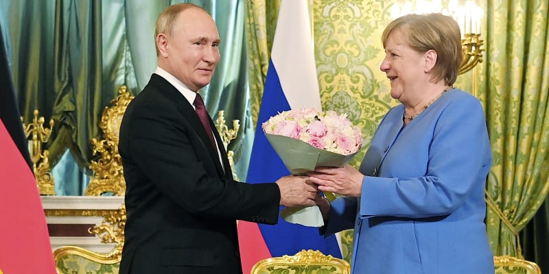 Německá kancléřka Angela Merkelová přijímá květiny od ruského prezidenta Vladimira Putina během návštěvy Kremlu v srpnu 2021.