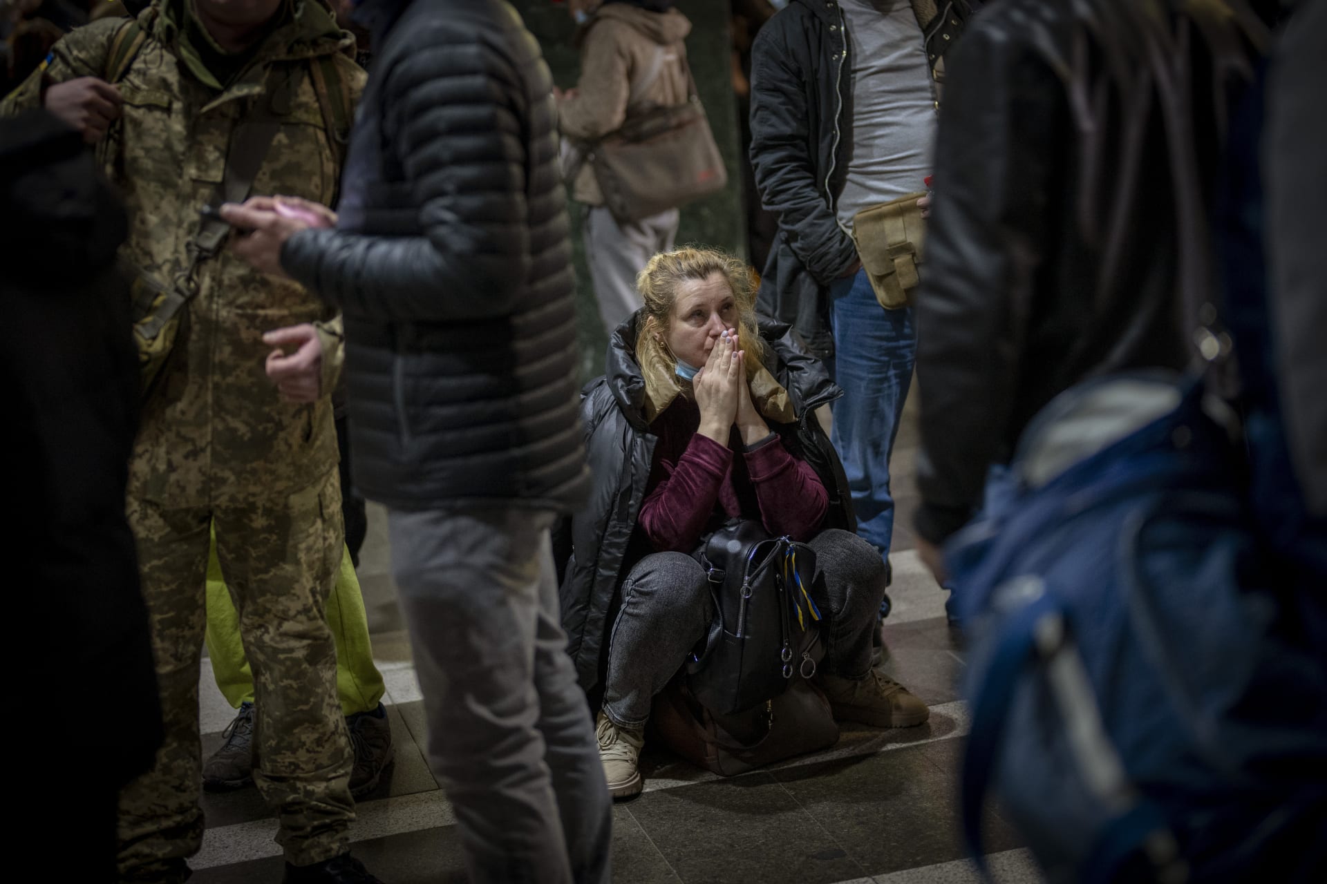 Lidé čekají na kyjevském nádraží, snaží se utéct do bezpečí. 