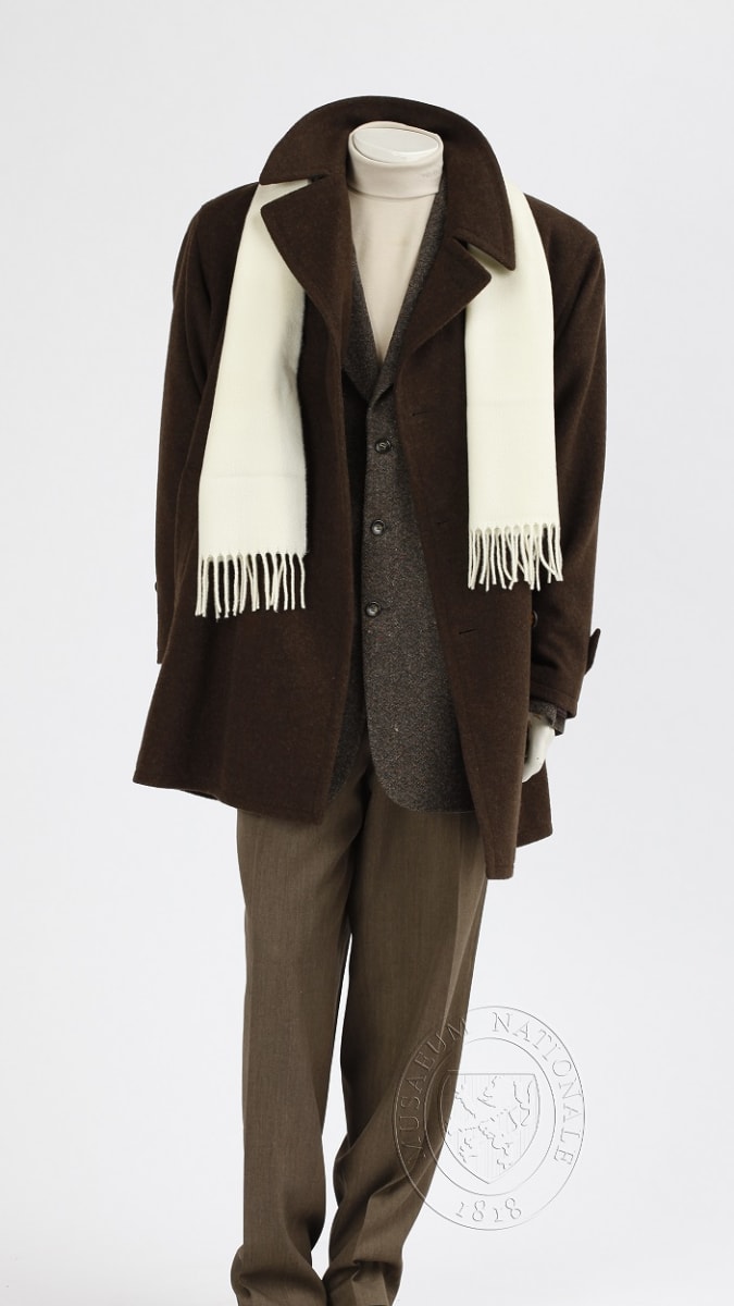 Pánský ceremoniální stejnokroj, ZOH Nagano 1998. Klasický oblek, s teplým vlněným kabátem, s bílou šálou a bekovkou, černé kožené boty. Sbírka Národního muzea, H7H-36326