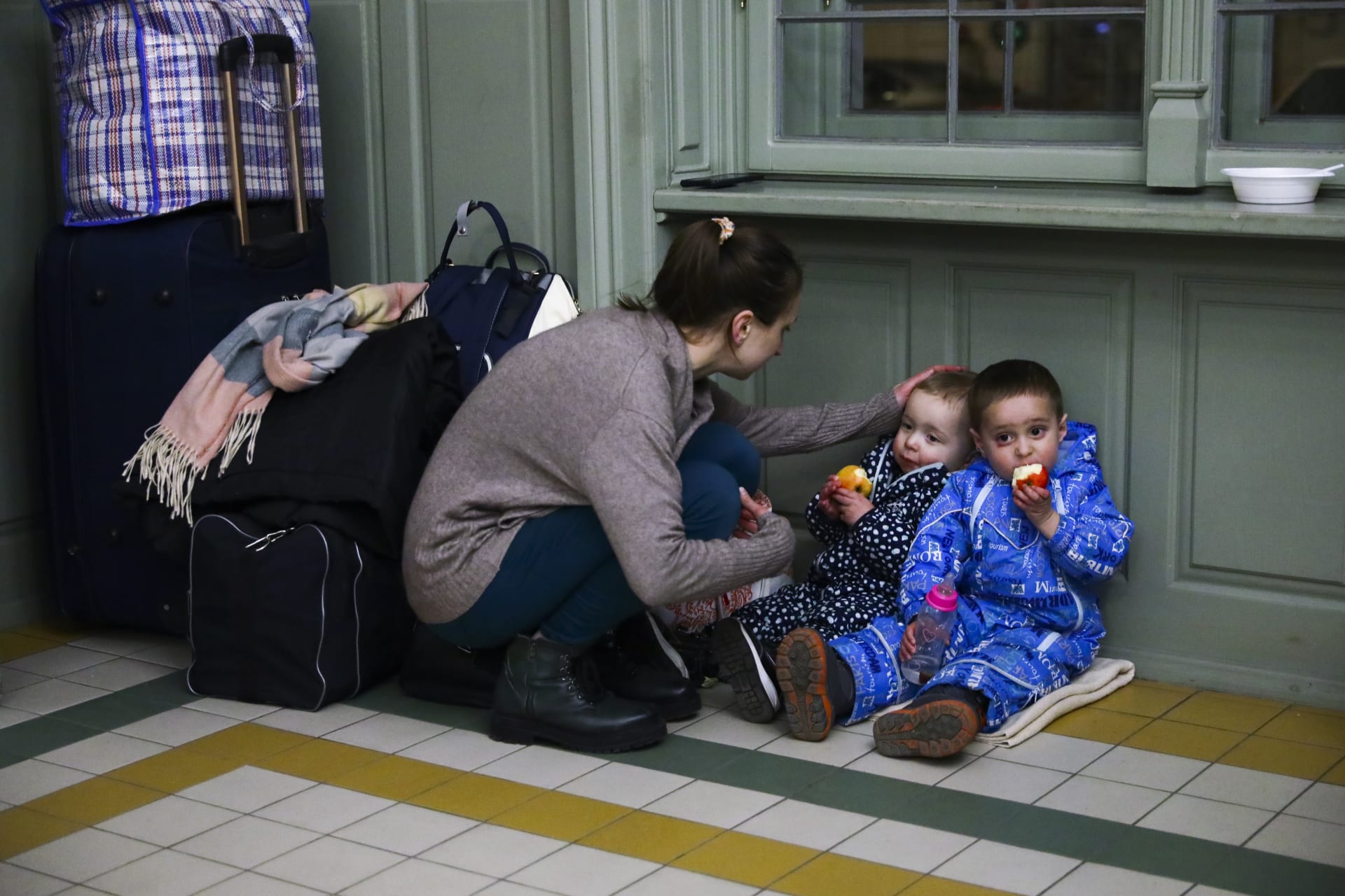 Matka s dětmi odpočívá v dočasném úkrytu v budově nádraží poté, co 24. února 2022 dorazila vlakem z Kyjeva na Ukrajině do polského Przemyslu.