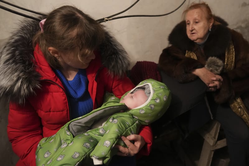 Žena chová své dítě v krytu v Mariupolu.