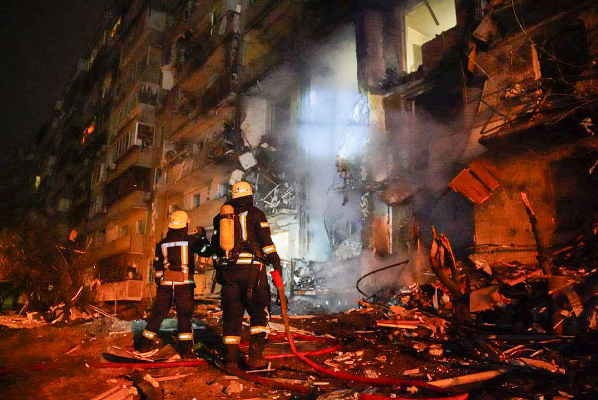 Hasiči kontrolují škody v budově po raketovém útoku na město Kyjev (sobota 26. února). 