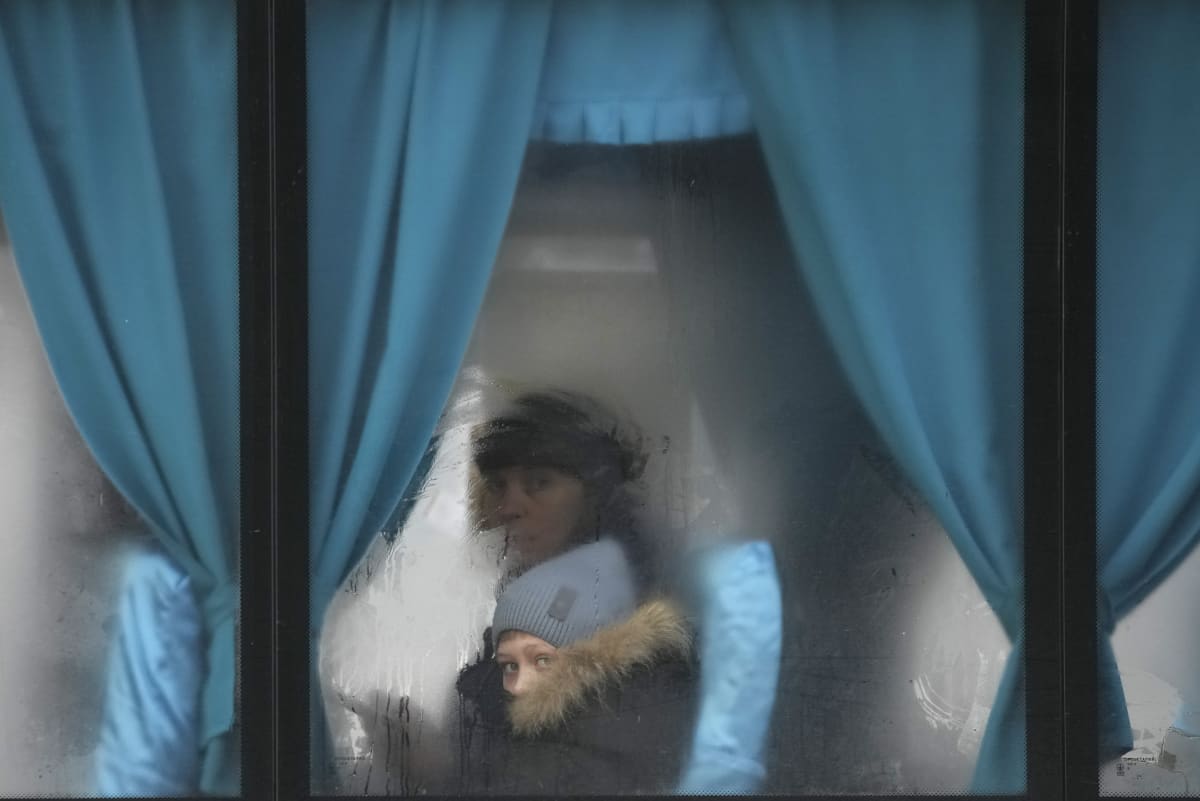 Žena se svým dítětem opouští Ukrajinu (24.2.2022)
