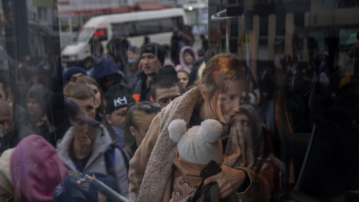 Žena drží své dítě a autobusem opouští Kyjev (24.2.2022)