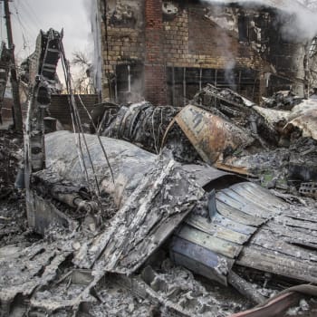 Ukrajinský hasič se prochází u fragmentů sestřeleného letadla v Kyjevě. (25.2.2022)