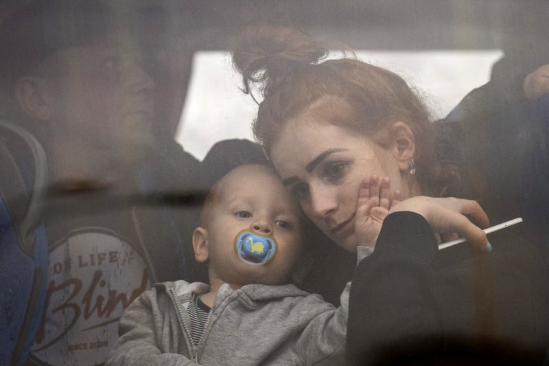 Žena drží své dítě a autobusem opouští Kyjev (24.2.2022)