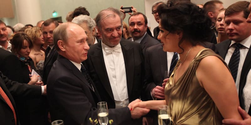 Ruský prezident Vladimir Putin se zdraví s operní zpěvačkou Annou Netrebko pospolu při otevření nového Marijinského divadla v Petrohradu. Mezi nimi je dirigent Valerij Gergijev.