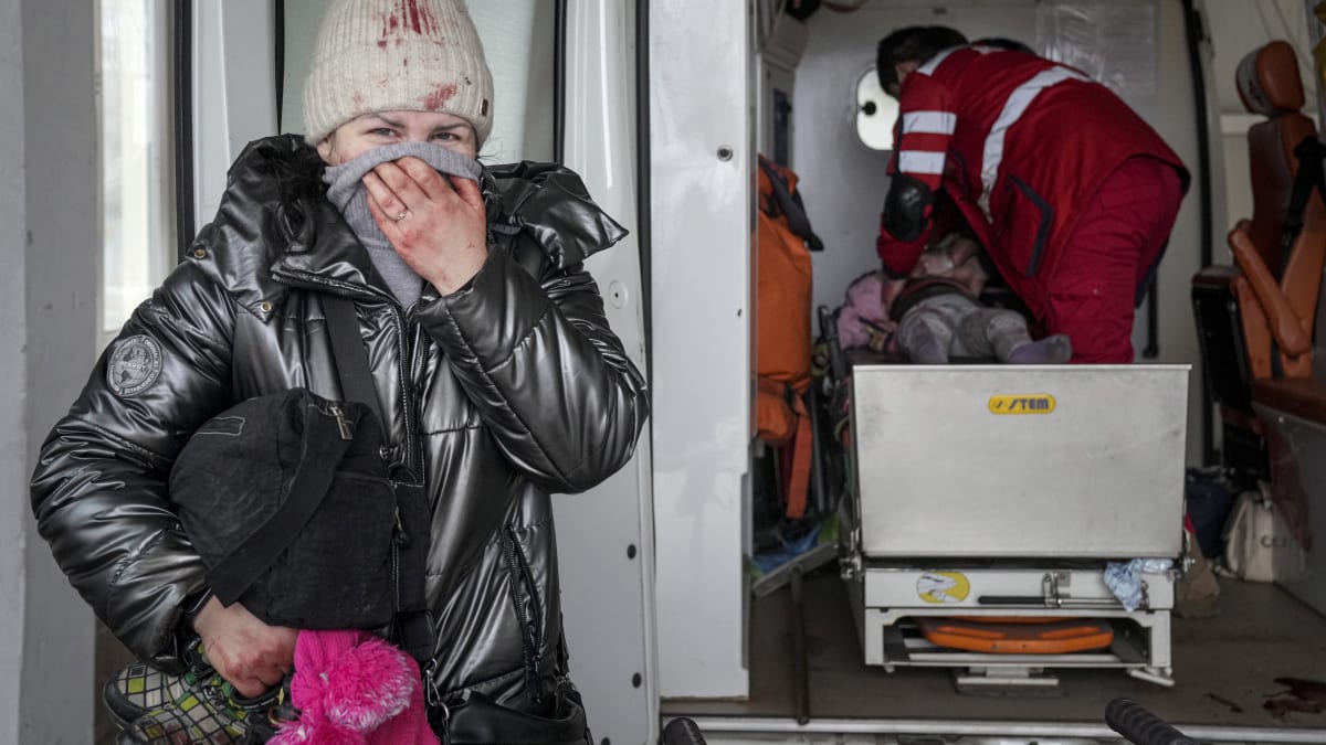 Žena reaguje, když zdravotníci provádějí resuscitaci dívky, která byla zraněna během ostřelování, v městské nemocnici v Mariupolu na východě Ukrajiny.