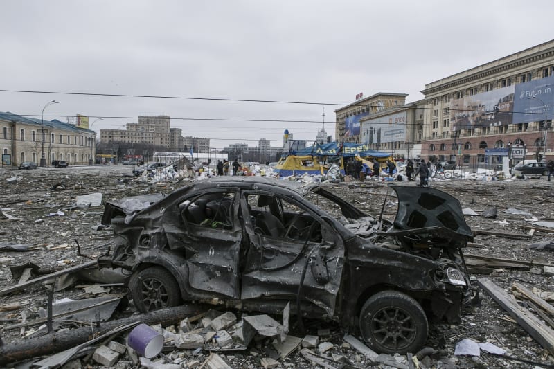 Poškozený automobil na centrálním náměstí po ostřelování budovy radnice v ukrajinském Charkově