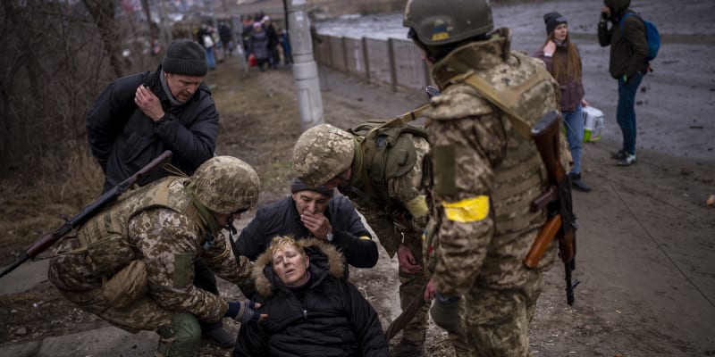 Lidé utíkají z kyjevského předměstí, ukrajinští vojáci jim pomáhají. (5. března 2022)