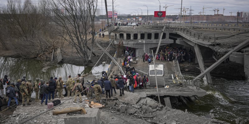 Lidé utíkají z kyjevského předměstí, ukrajinští vojáci jim pomáhají. (5. března 2022)