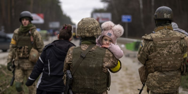 Prchající obyvatelé kyjevského předměstí, ukrajinští vojáci jim pomáhají. (5. března 2022)