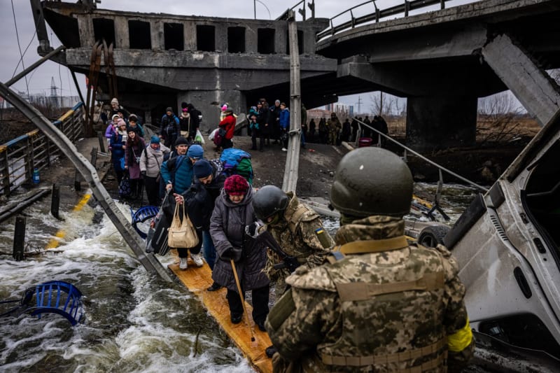 Evakuovaní Ukrajinci přechází přes zničený most při útěku z města Irpiň severozápadně od Kyjeva  7. března 2022