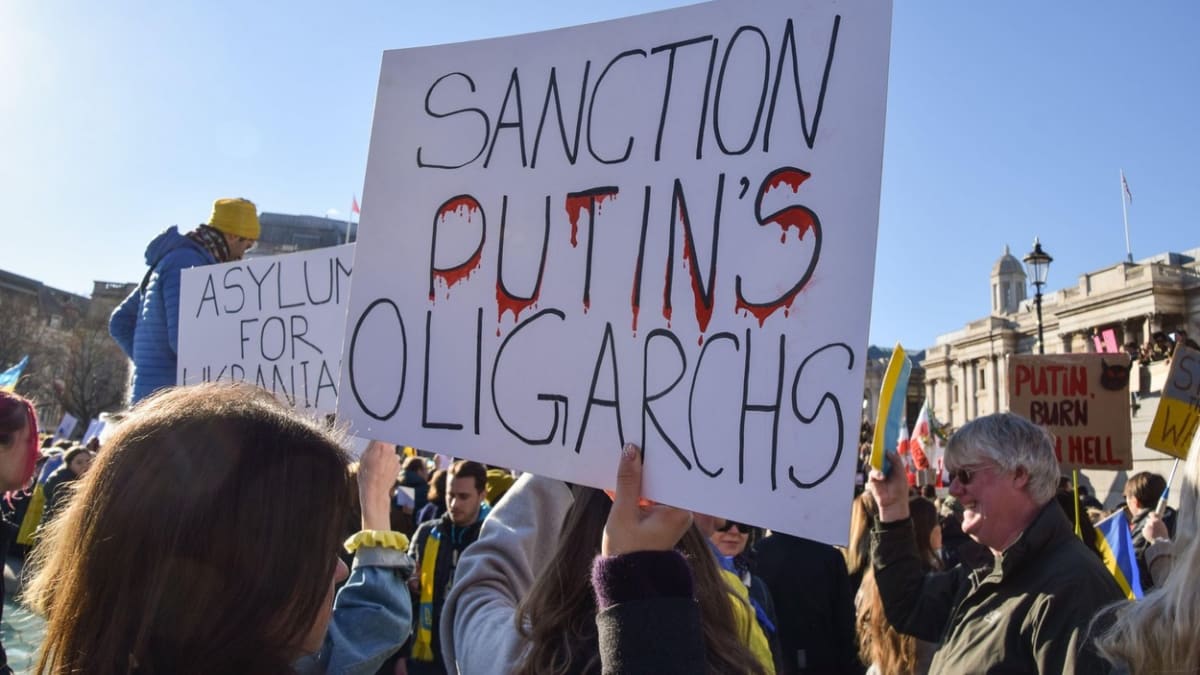Sankce na Putinovy oligarchy, vyzývá transparent na protestu proti ruské invazi v Londýně.