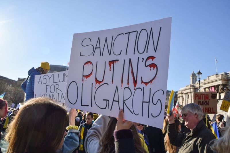 Sankce na Putinovy oligarchy, vyzývá transparent na protestu proti ruské invazi v Londýně.