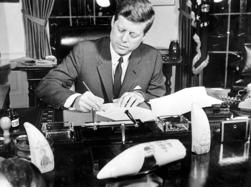 John F. Kennedy podepisuje výnos, kterým nařizuje blokádu ostrova Kuba.