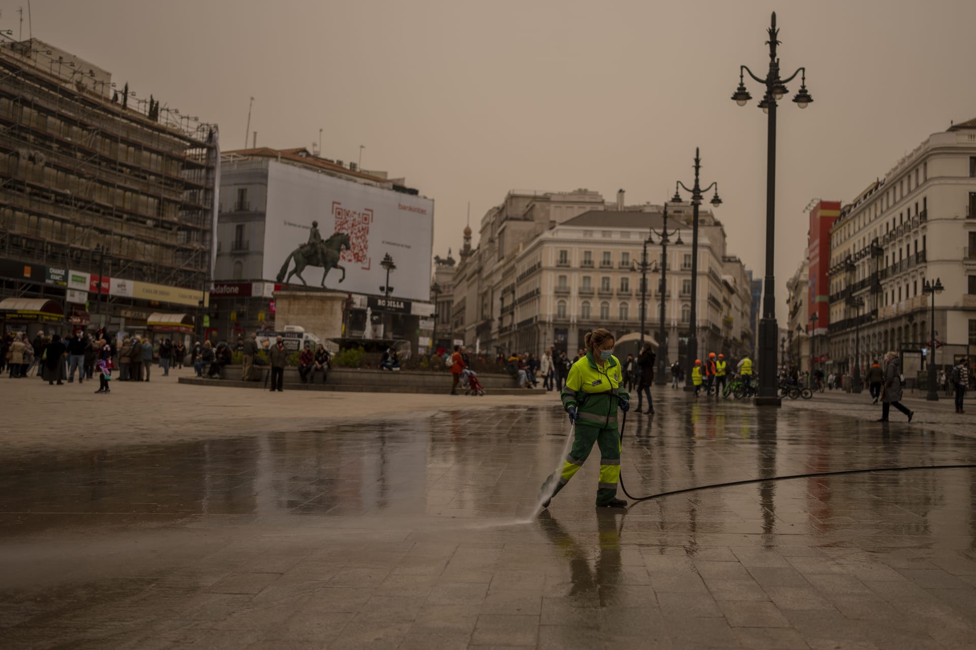 Pracovník města uklízí písek v centru Madridu.