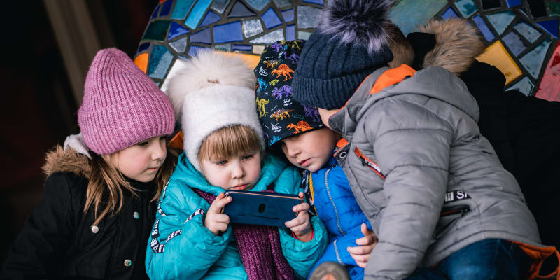 Některé děti uprchlíků si krátí čas sledováním videí na mobilním telefonu.