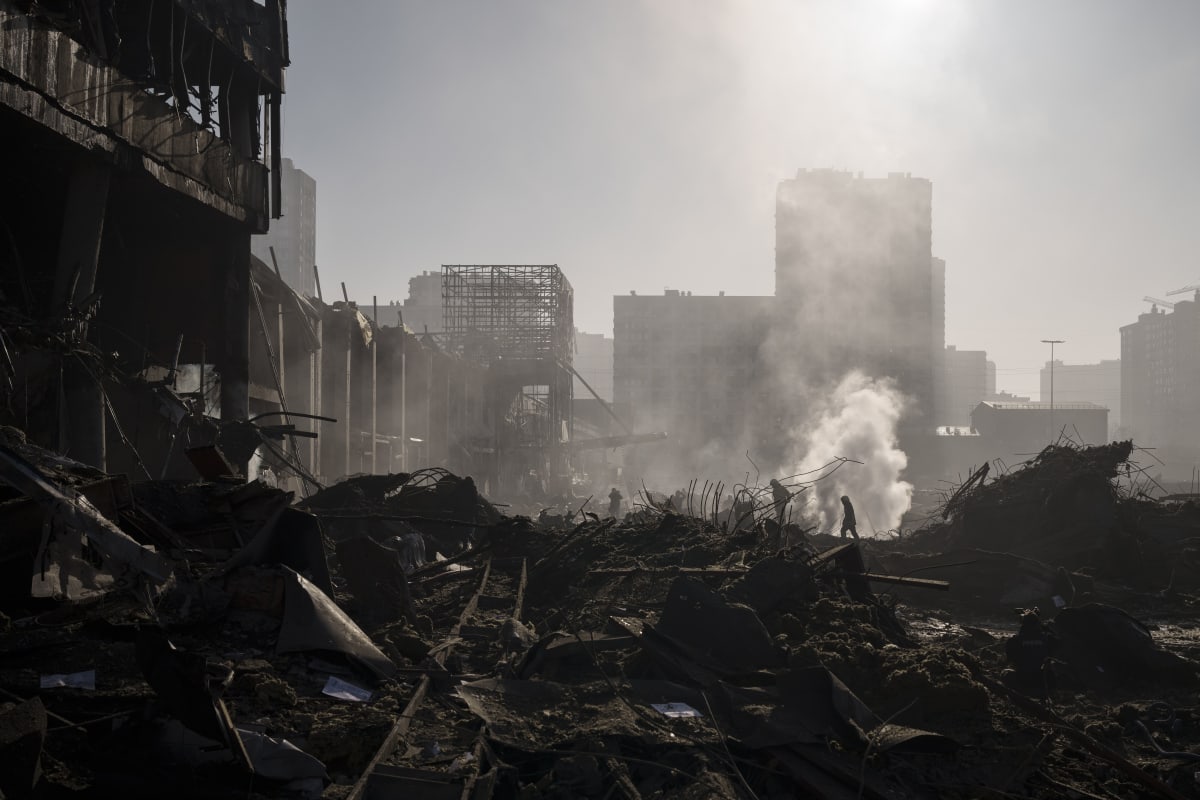 Hasiči hasí požár u nákupního centra po ostřelování Kyjeva (21. března 2022).
