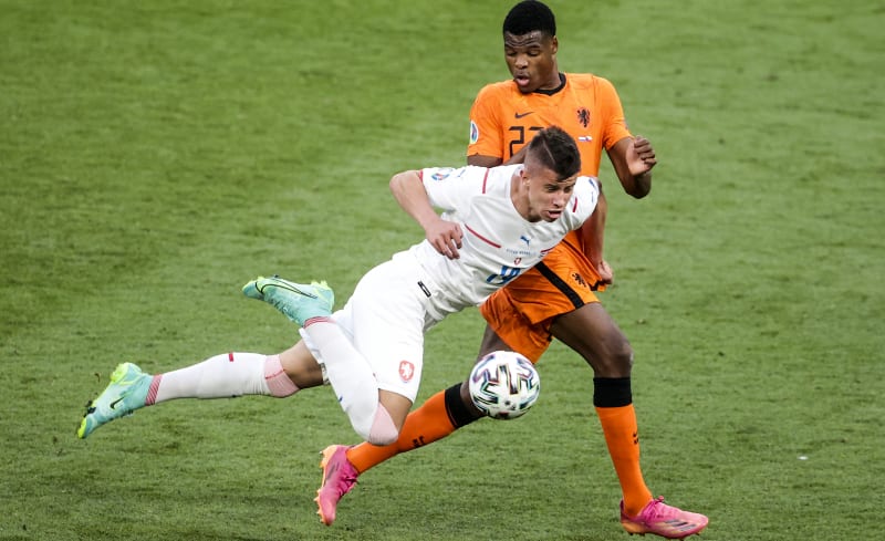 Český fotbalista Adam Hložek (v bílém) se snaží obejít Nizozemce Denzela Dumfriese ve vítězném osmifinálovém utkání mistrovství Evropy 2021, které se hrálo v červnu v Budapešti.