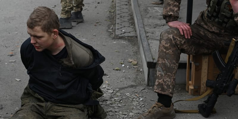 Ukrajinský voják vyslýchá zajatého ruského vojáka. (5. března 2022)