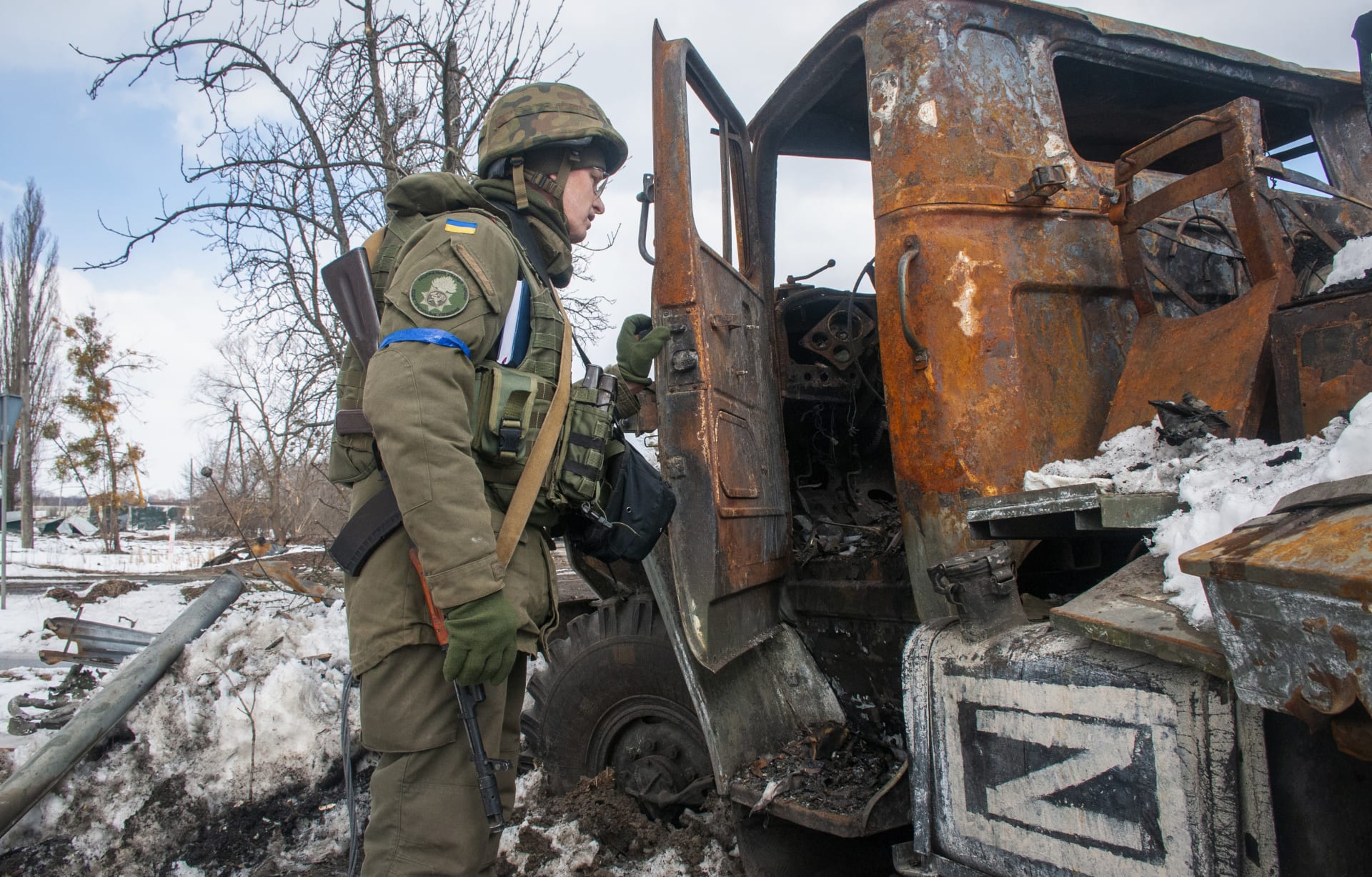 Ukrajinský voják prohlíží poškozené ruské bojové vozidlo u Charkova. (16. března)