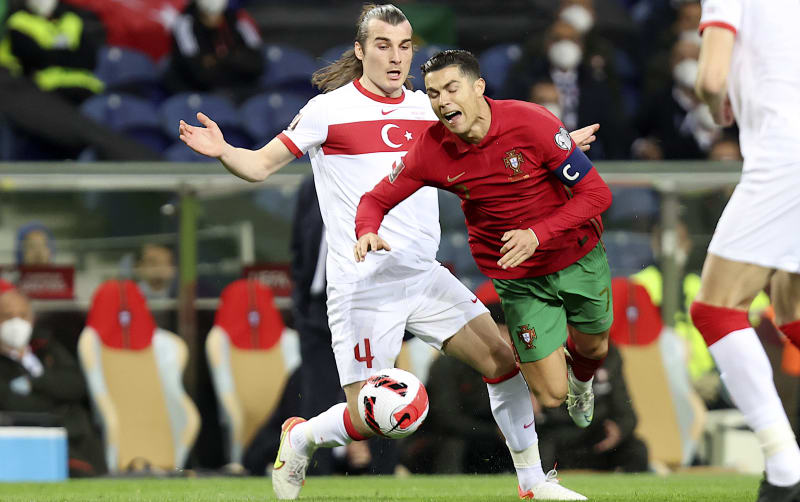 Portugalský kapitán Cristiano Ronaldo padá v souboji s Turkem Caglarem Soyuncu v kvalifikačním utkání o postup na mistrovství světa 2022. Portugalci zvítězili v Portu 3:1. 