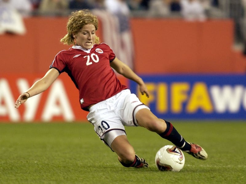 Norská záložnice Lise Klavenessová odehrává ve skluzu míč v zápase čtvrtfinále mistrovství světa proti USA, který se hrál v říjnu 2003 na stadionu v americkém Foxboro.