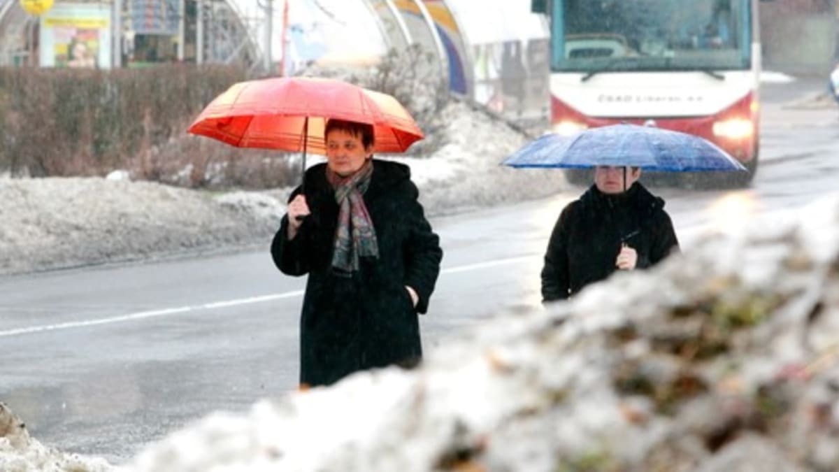 Lidé s deštníky v zimě 