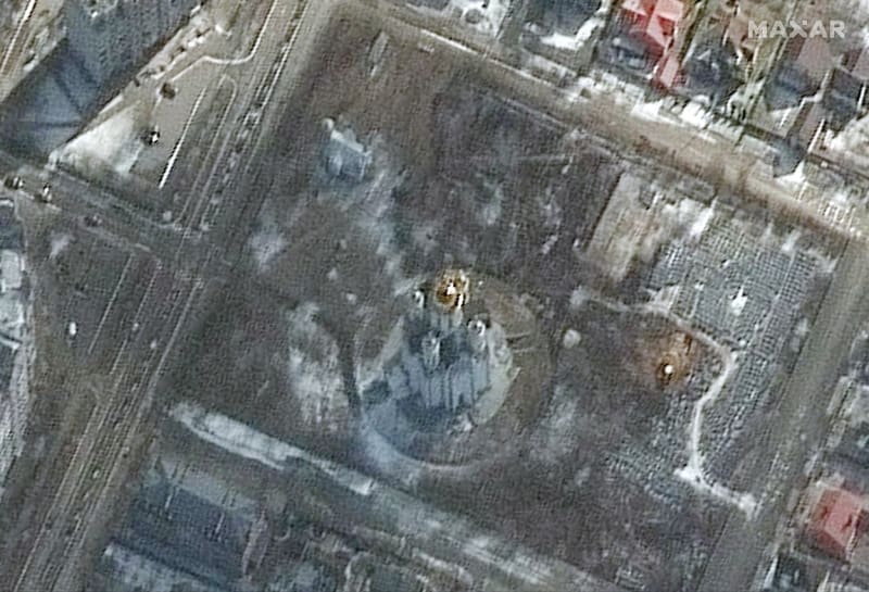 Satelitní snímek zveřejněný společností Maxar Technologies 3. dubna 2022 ukazuje pravděpodobný výkop zeminy na hrobovém místě (R) poblíž kostela svatého Ondřeje v Buči na Ukrajině už 10. března 2022.