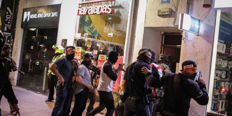 Policisté v civilu zasahují na místě teroristického útoku v Tel Avivu.