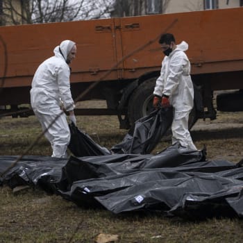 Zaměstnanci hřbitova vyzvedávají těla z masového hrobu v Buči, aby mohla být identifikována