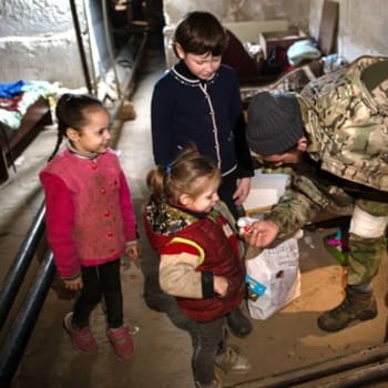 Ruský voják mluví s dětmi ve městě Rubežnoje v Luhanské oblasti
