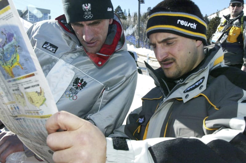 Německý sáňkař Georg Hackl (vpravo) a jeho rakouský soupeř Markus Prock čtou noviny při olympijských hrách 2002 v americkém Salt Lake City. Němec po třech předchozích zlatech z let 1992, 1994 a 1998 získal stříbro, Rakušan bronz. Porazil je Ital Armin Zöggeler.