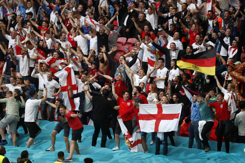 Angličtí fotbaloví fanoušci se radují z vítězství 2:0 v osmifinále mistrovství Evropy 2020 nad Německem, které se hrálo kvůli pandemii koronaviru až v červnu 2021 v Londýně. 
