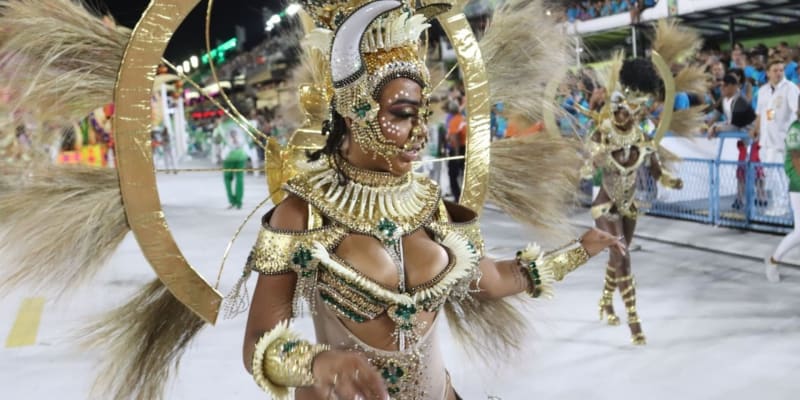 Do zlatého kostýmu oblečená tanečnice jedné ze škol samby přivádí svou skupinu na sambodrom Marquês de Sapucaí v brazilském Riu de Janeiru.