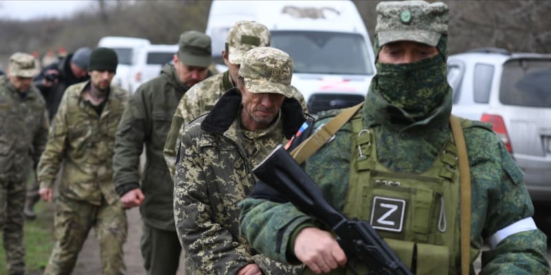 Ruský voják vede ukrajinské válečné zajatce.