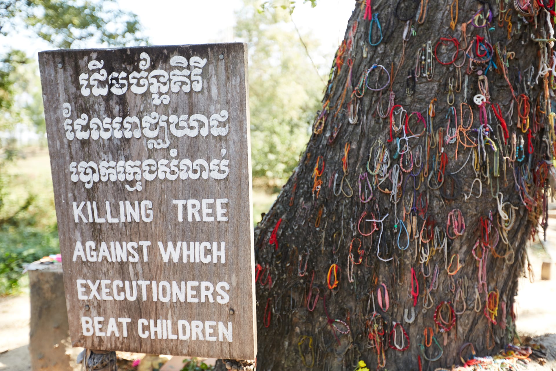 Nápis u stromu, kde Rudí Khmérové často mučili děti 