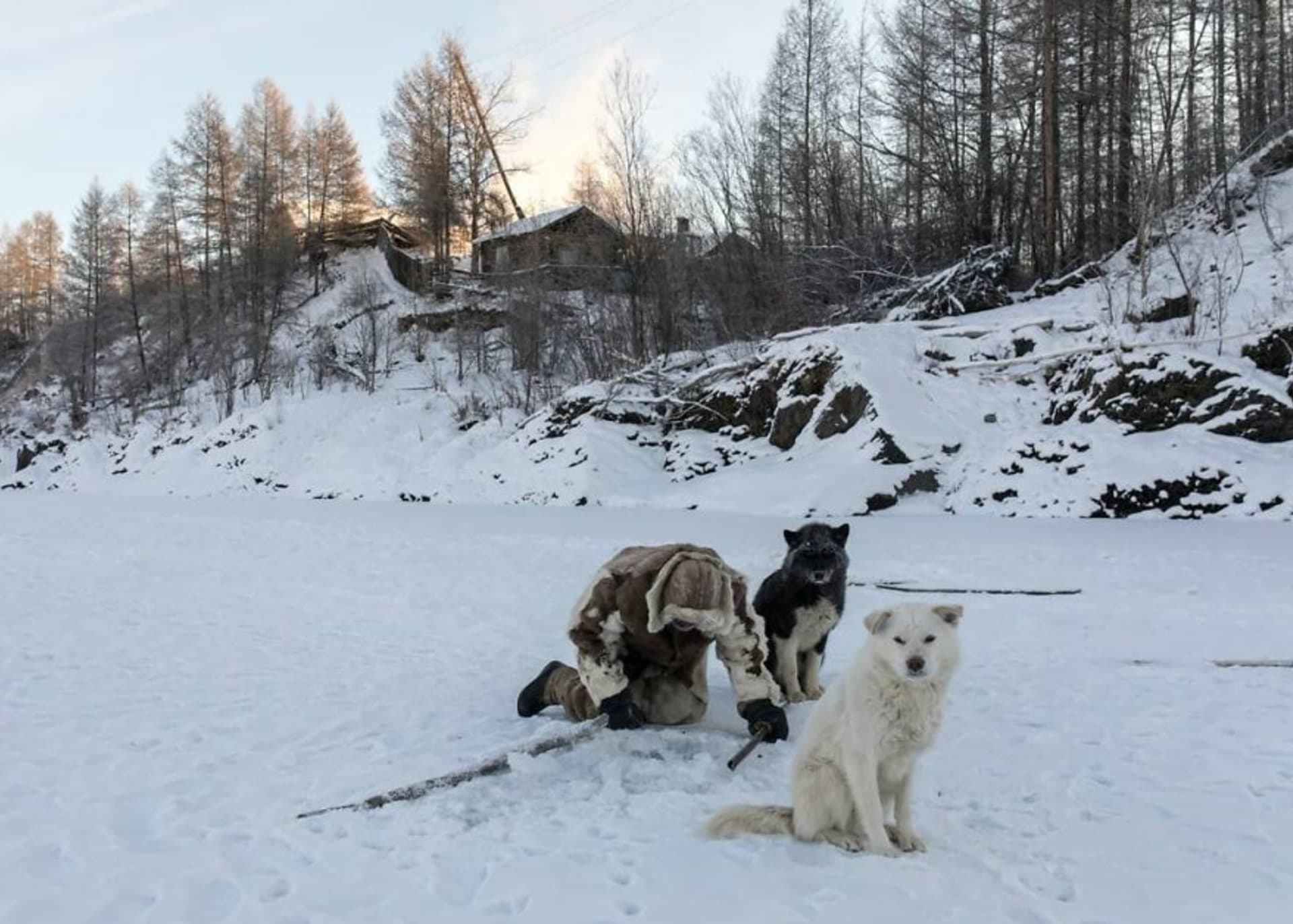 Rybář Innokentij Androsov ve vesnici Topolinoje pod dohledem svých psů