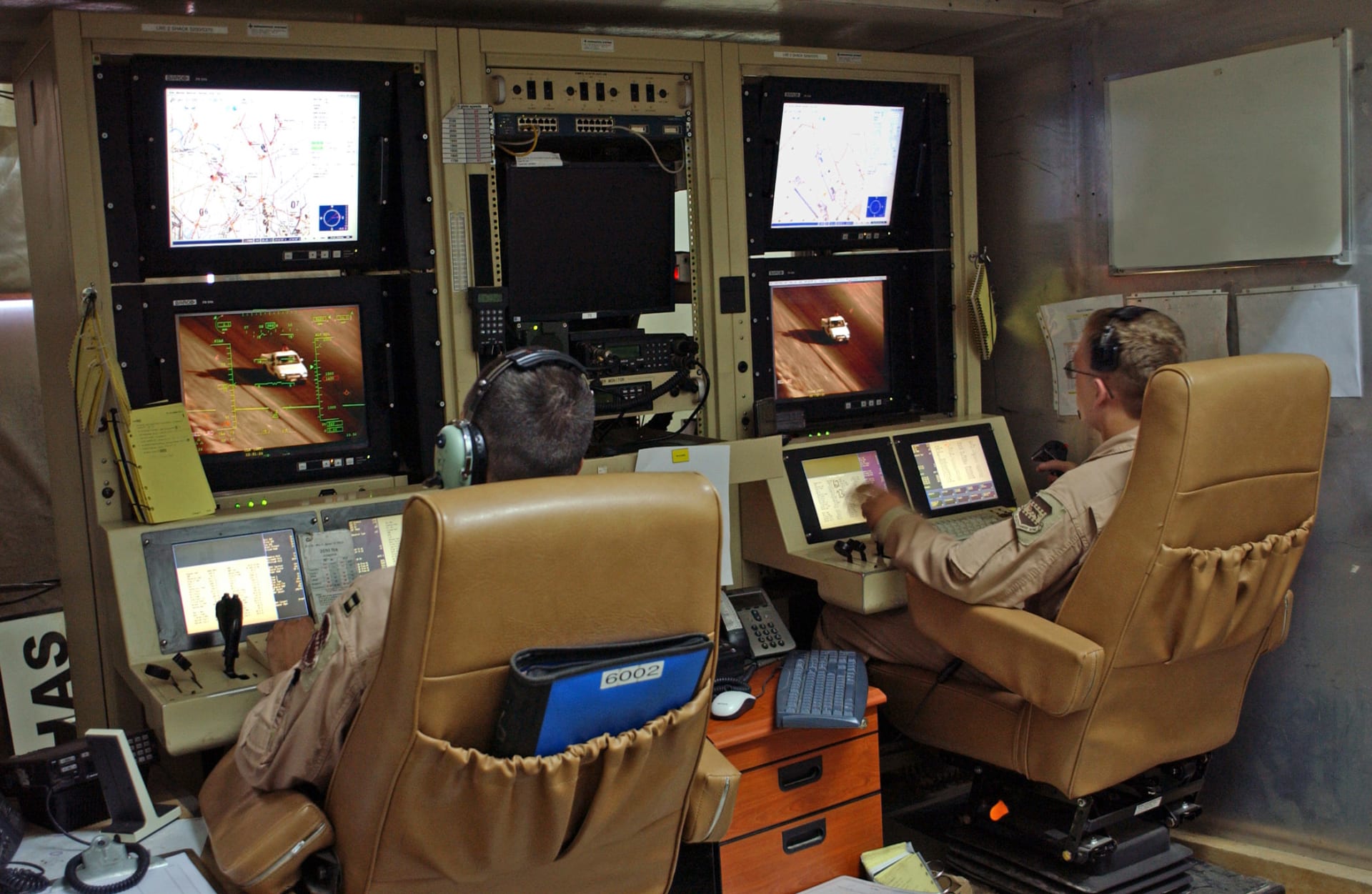 Operátor a pilot dronu u svých obrazovek v Nevadě