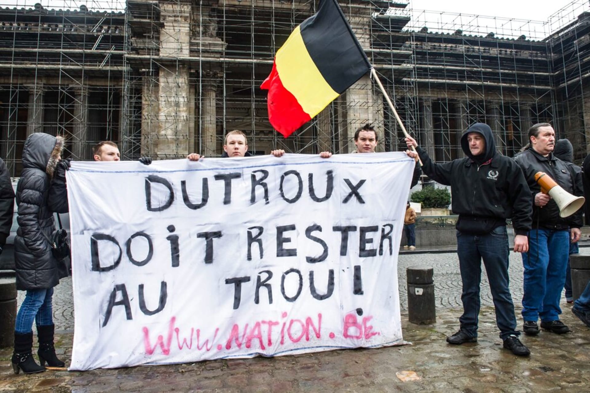 Demonstranti s transparentem „Dutroux musí zůstat v cele!“