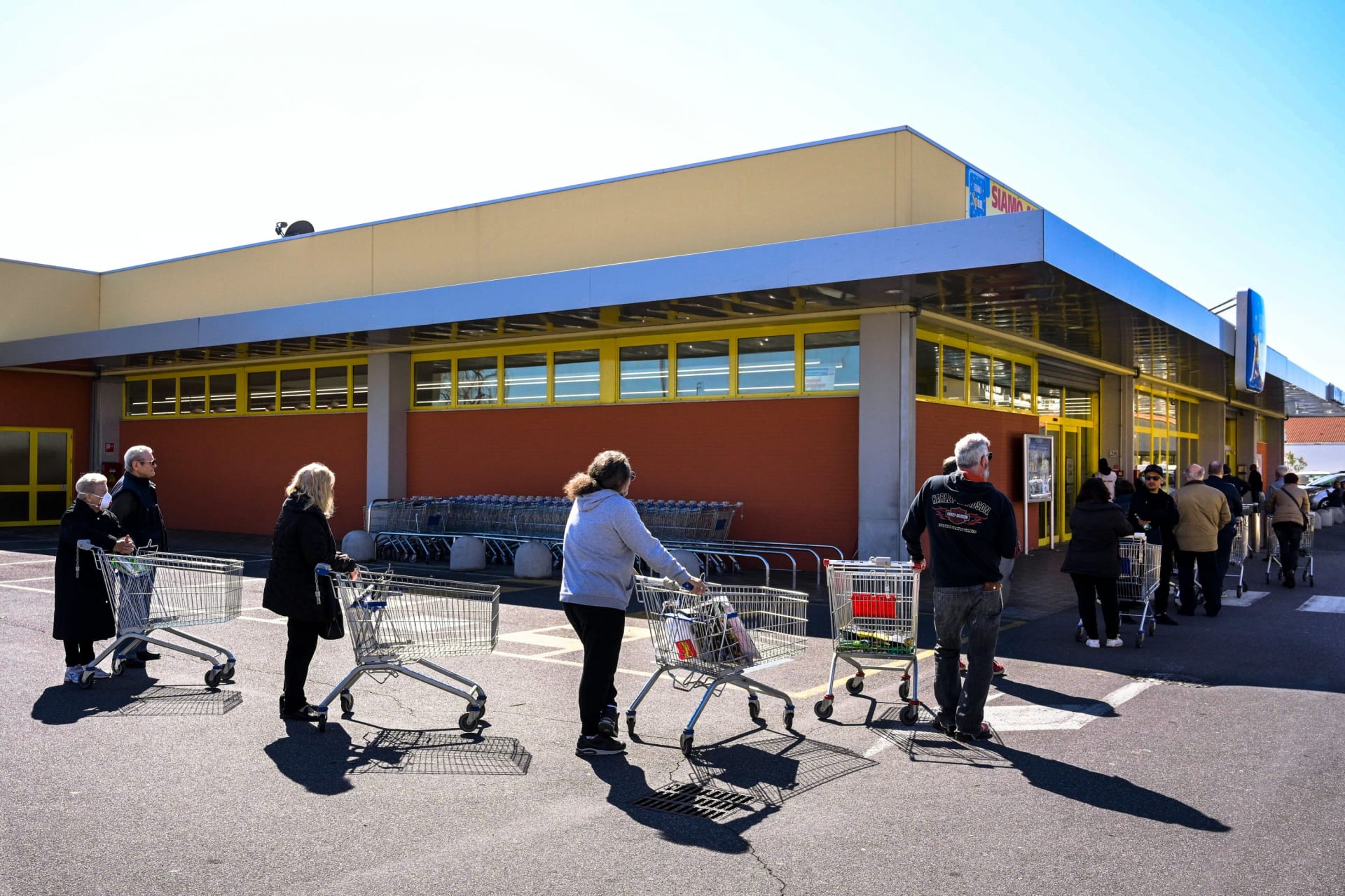 Italové čekají ve frontě u supermarketu nedaleko Říma