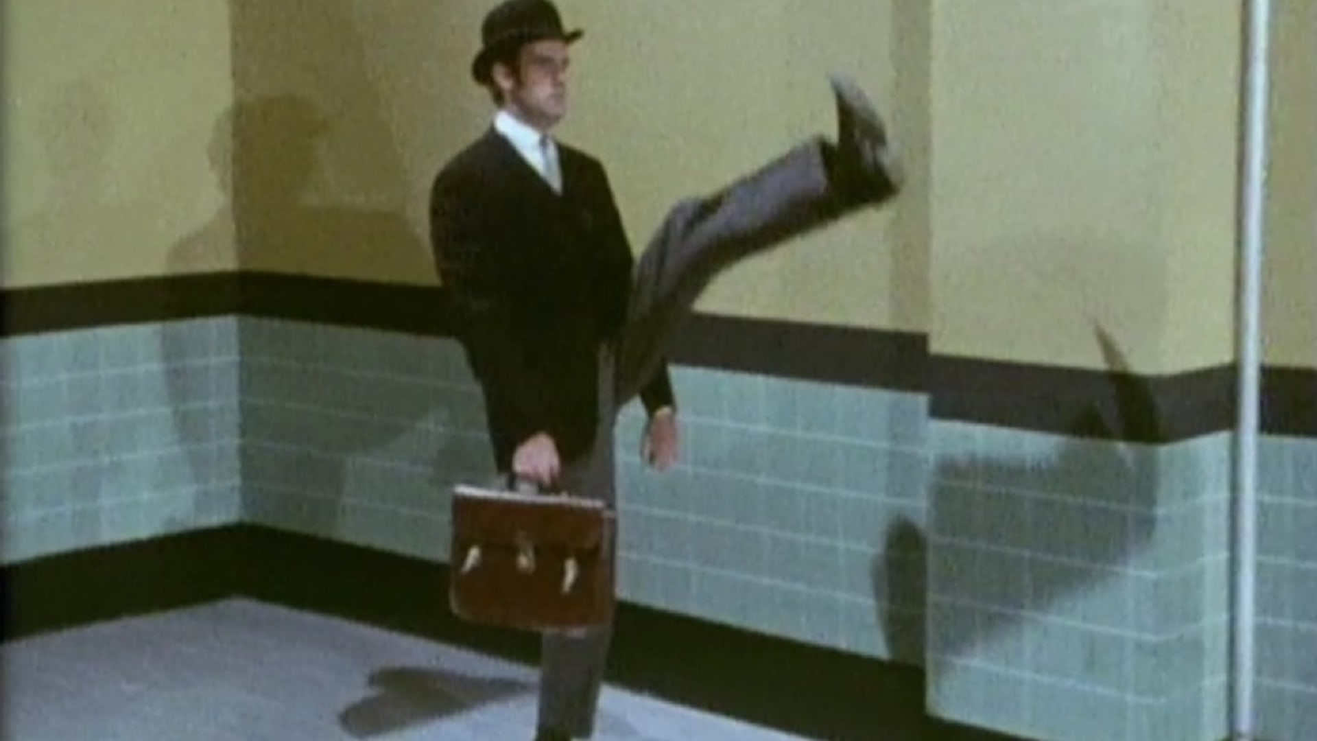 John Cleese z komediální skupiny Monty Python ve slavném skeči "Ministerstvo švihlé chůze".