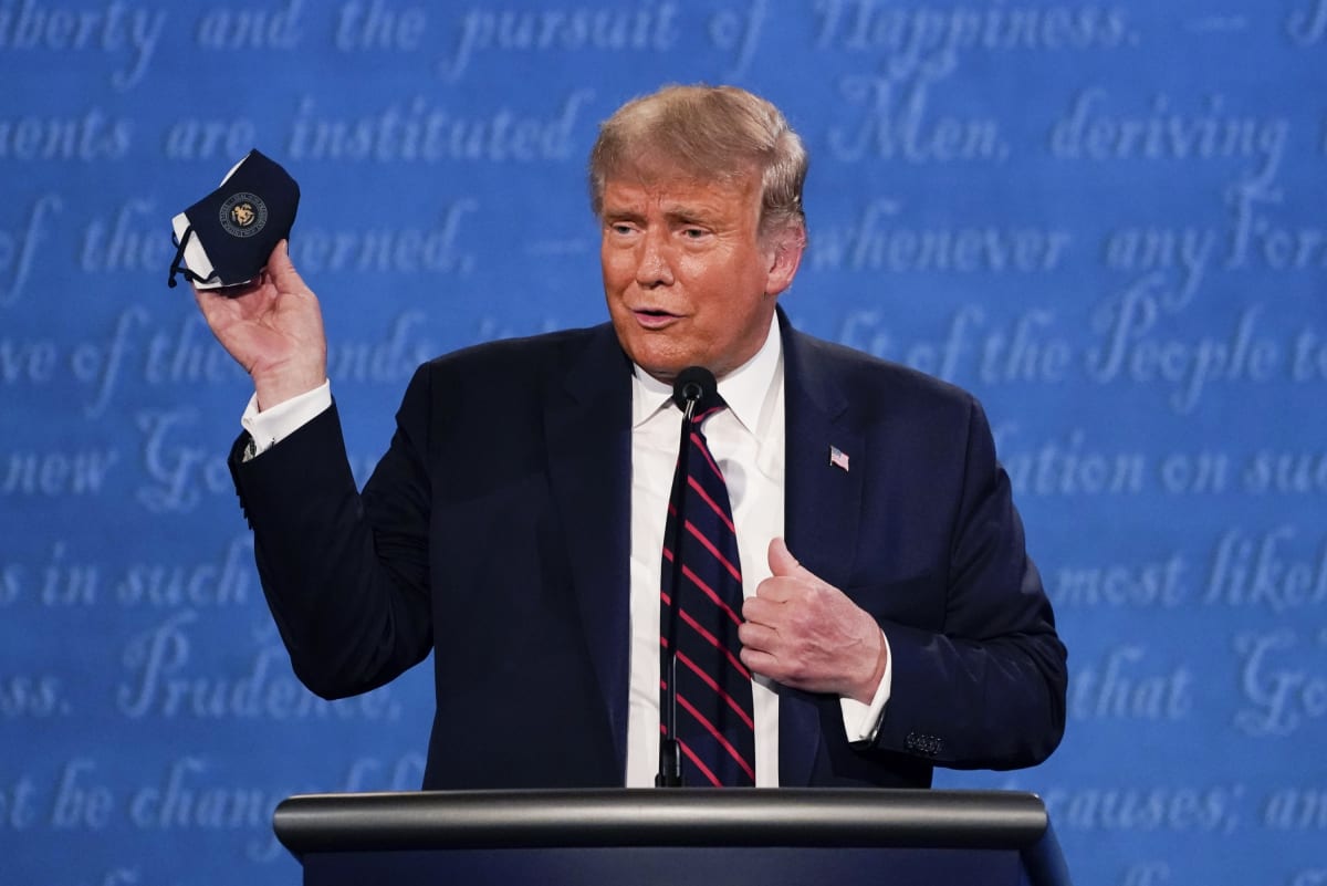 Donald Trump během první prezidentské debaty 29. září 2020 mává svou rouškou. O dva dny později měl pozitivní test na koronavirus