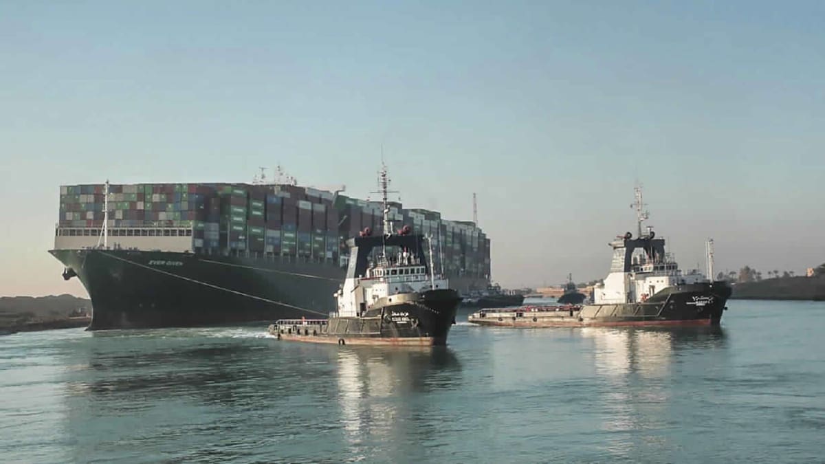 Remorkéry vlečou obří kontejnerovou loď Suezským průplavem