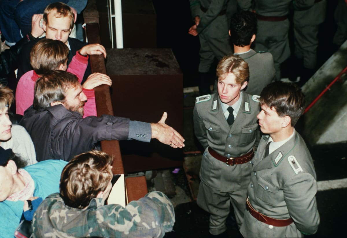 Přechody jsou otevřeny, ale východoněmečtí vojáci si poblíž Checkpoint Charlie odmítají potřást rukou (10. listopadu 1989)