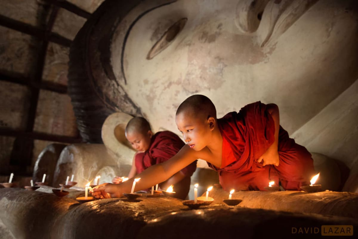 Mniši zapalují svíčky v Baganu